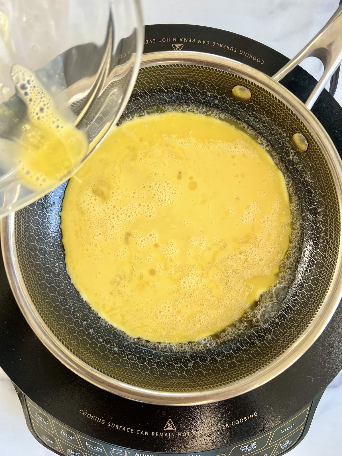 Eggs poured in a skillet.