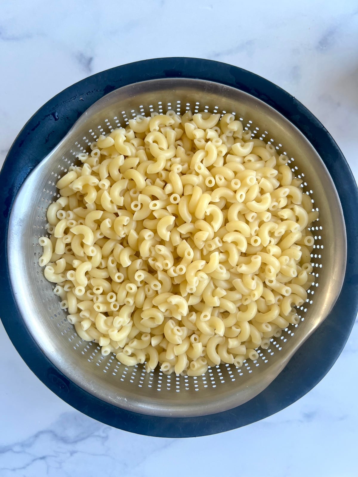 Noodles draining in a strainer.