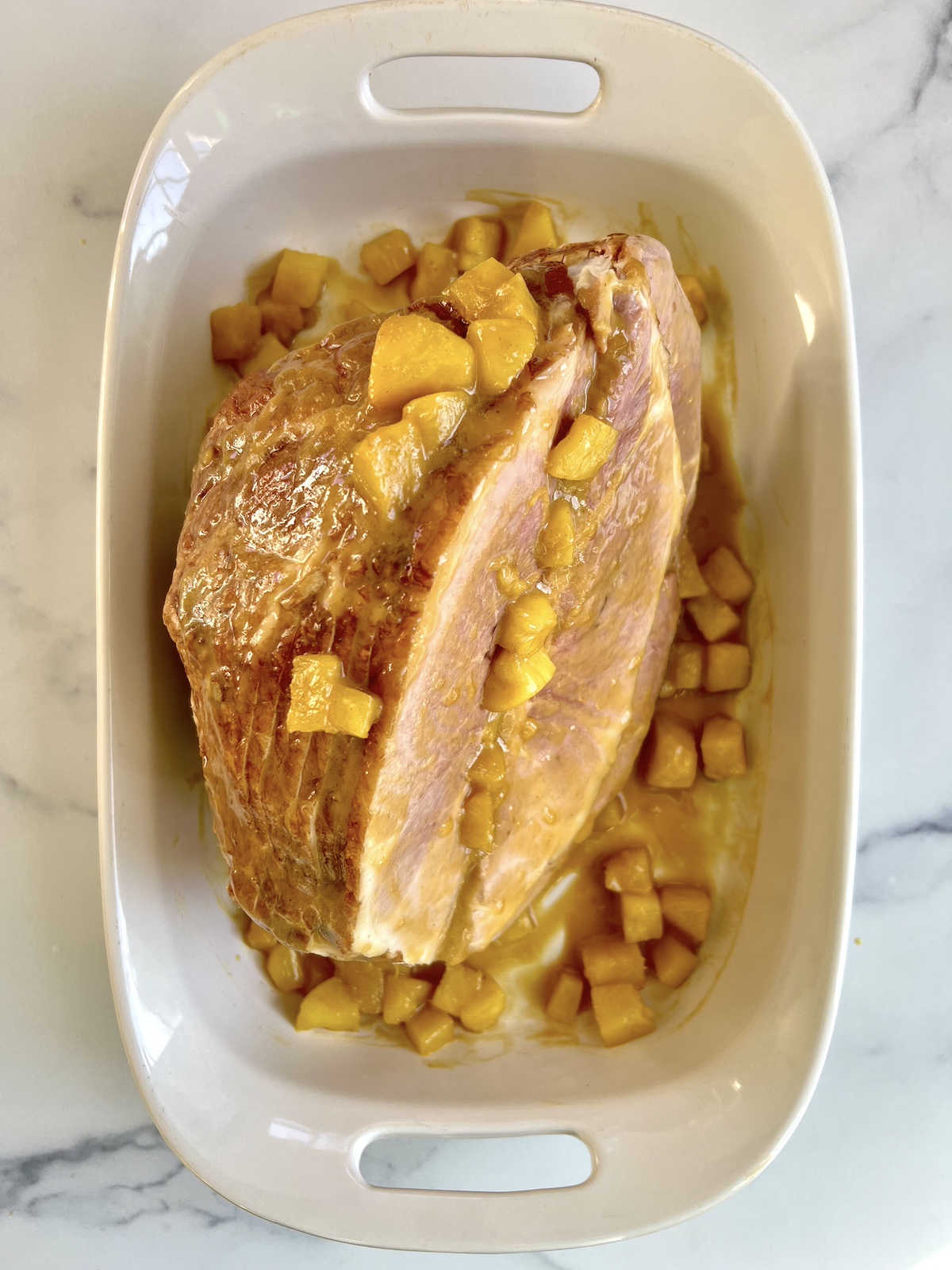 Pineapple over ham in a baking dish.