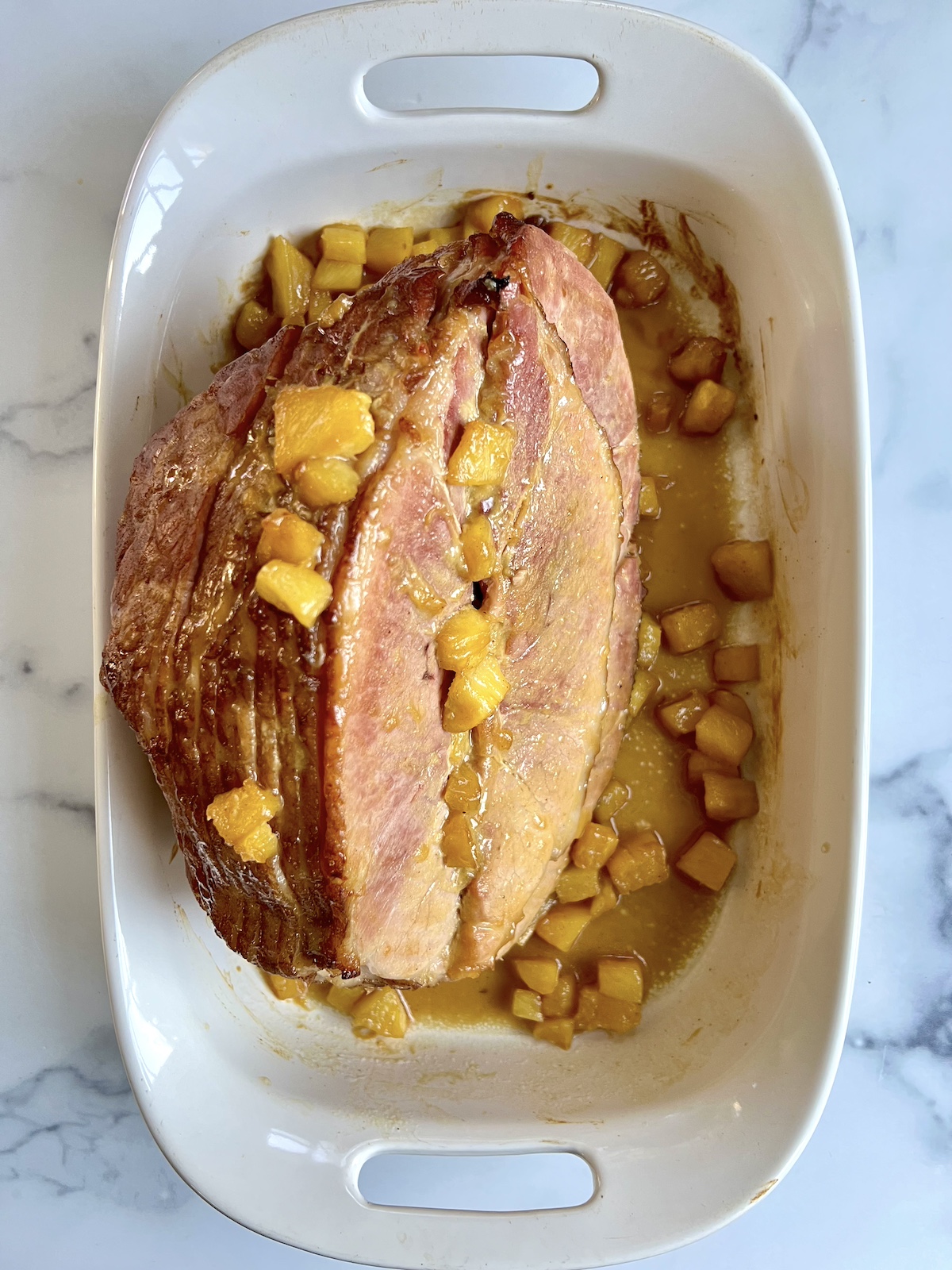 Roasted pineapple glazed ham in baking dish.