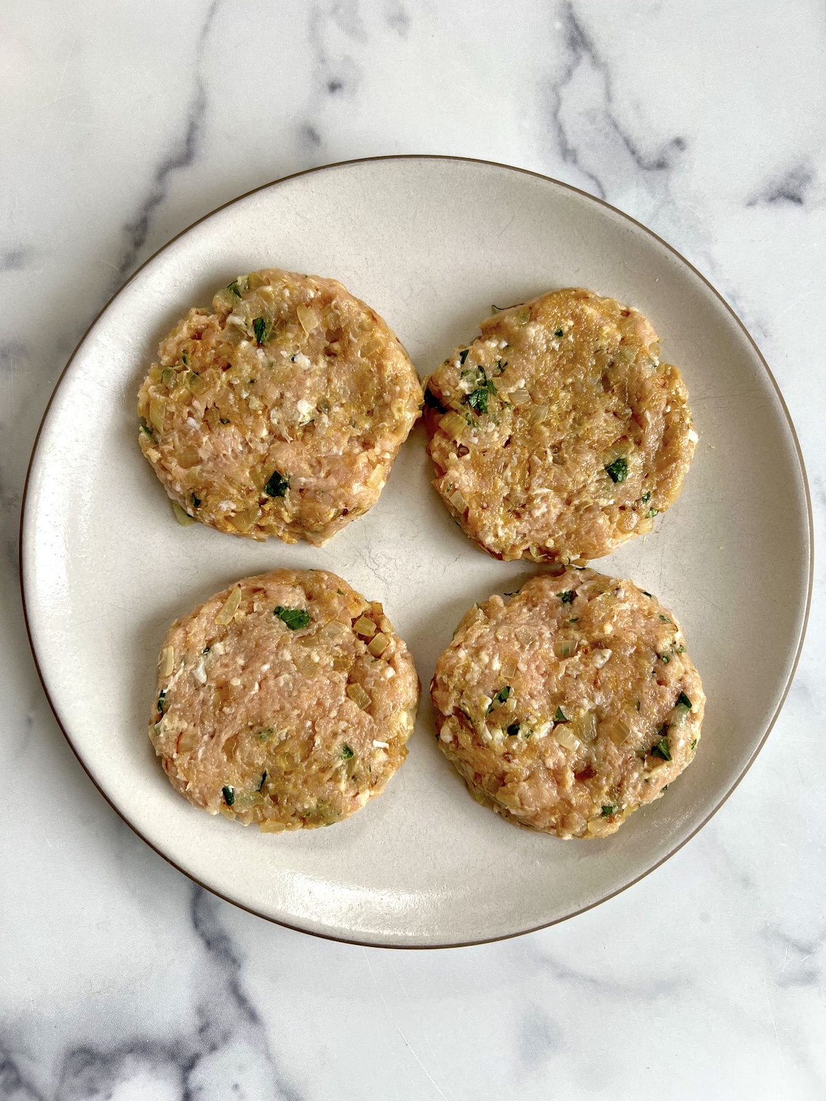 Chicken burgers patties on a plate.