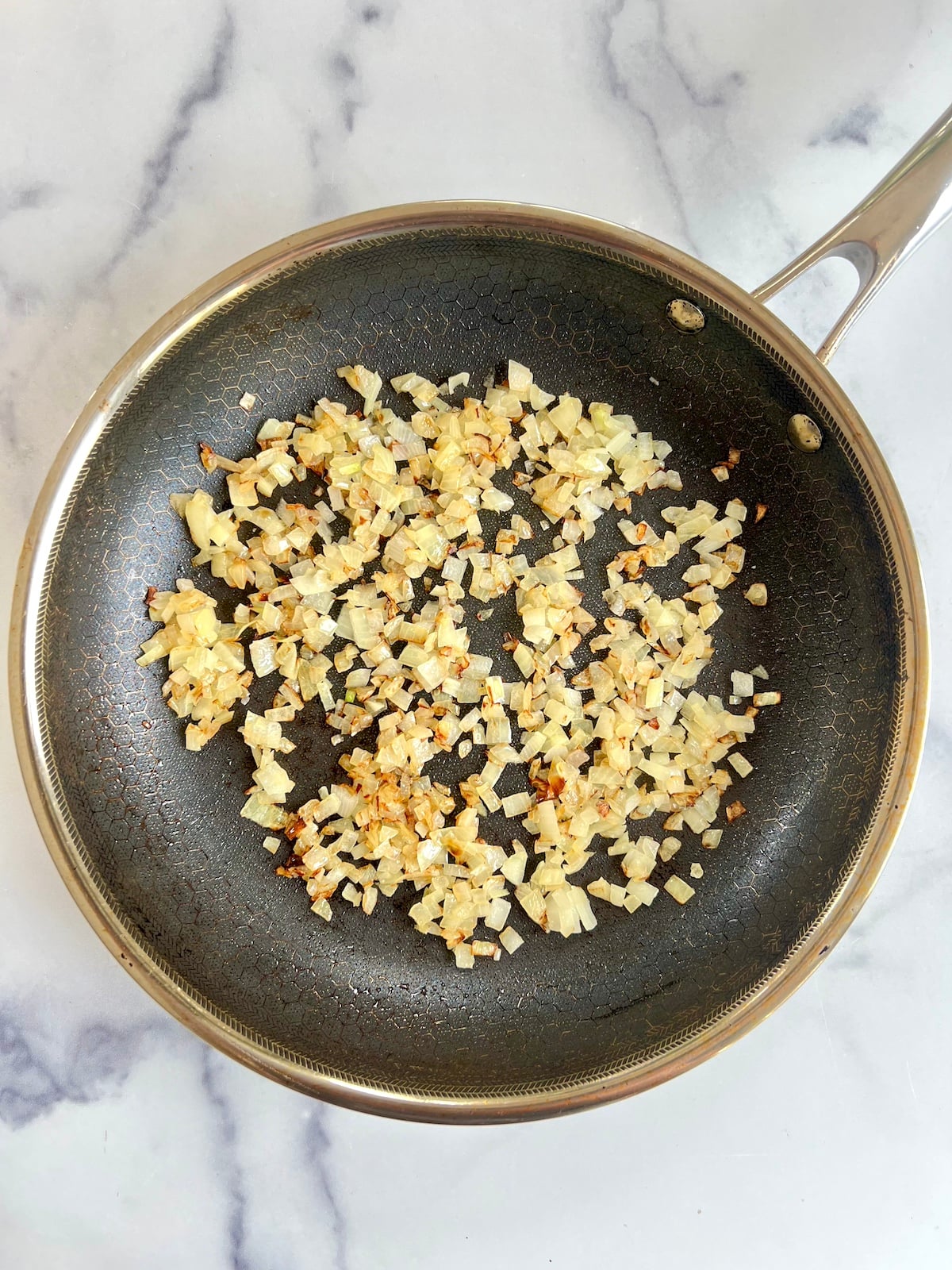 Sautéed onion in a sauté pan.