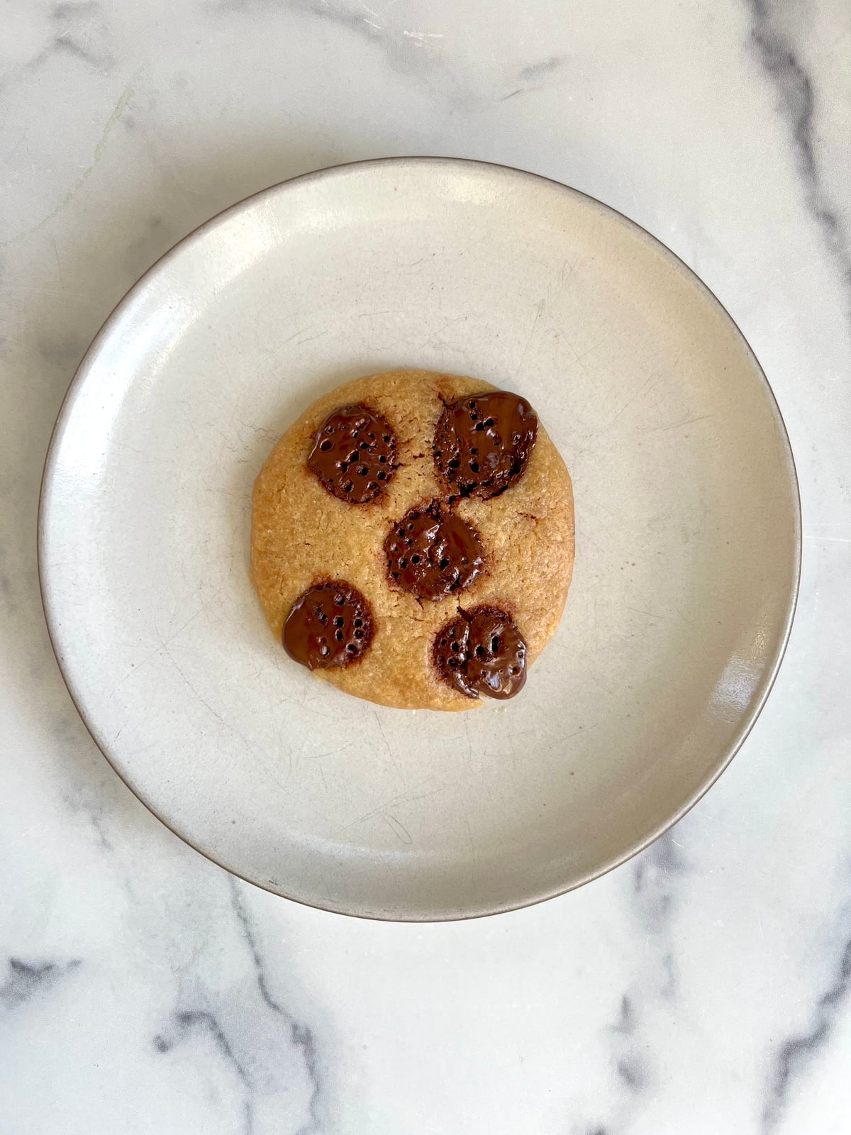 Microwave chocolate chip cookie on a plate.