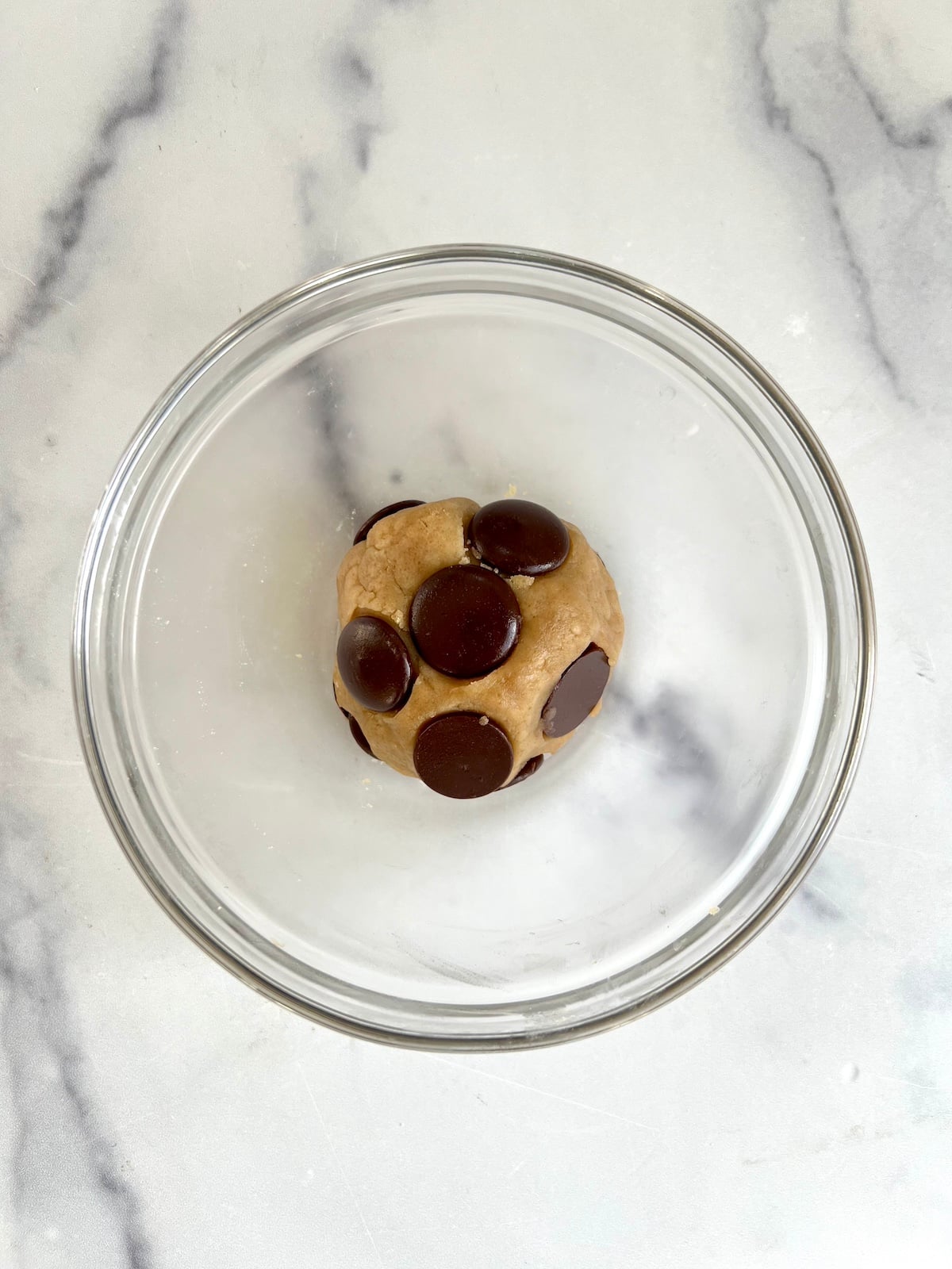 Single serving of chocolate chip cookie dough in a bowl.