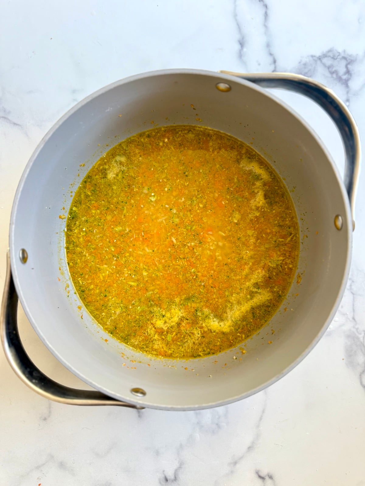 Orzo cooking in chicken broth.