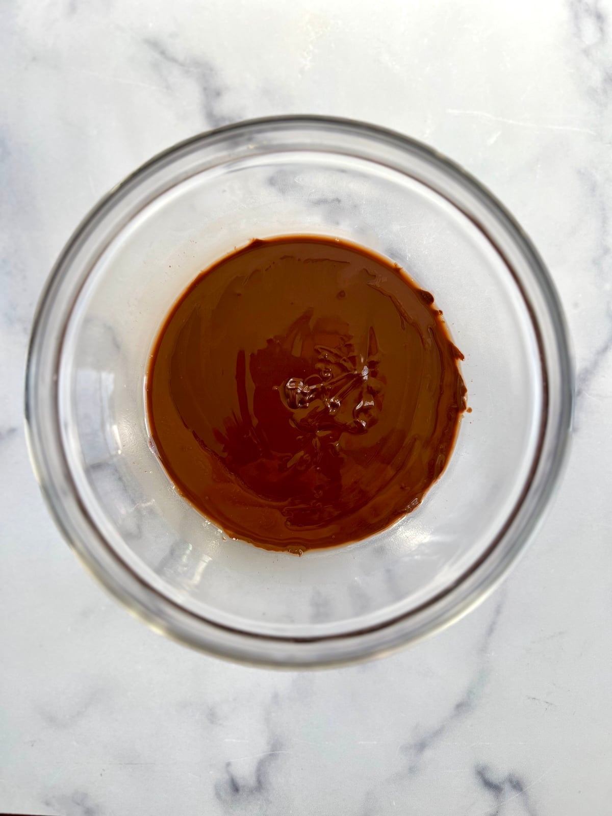 Melted chocolate in a glass bowl.