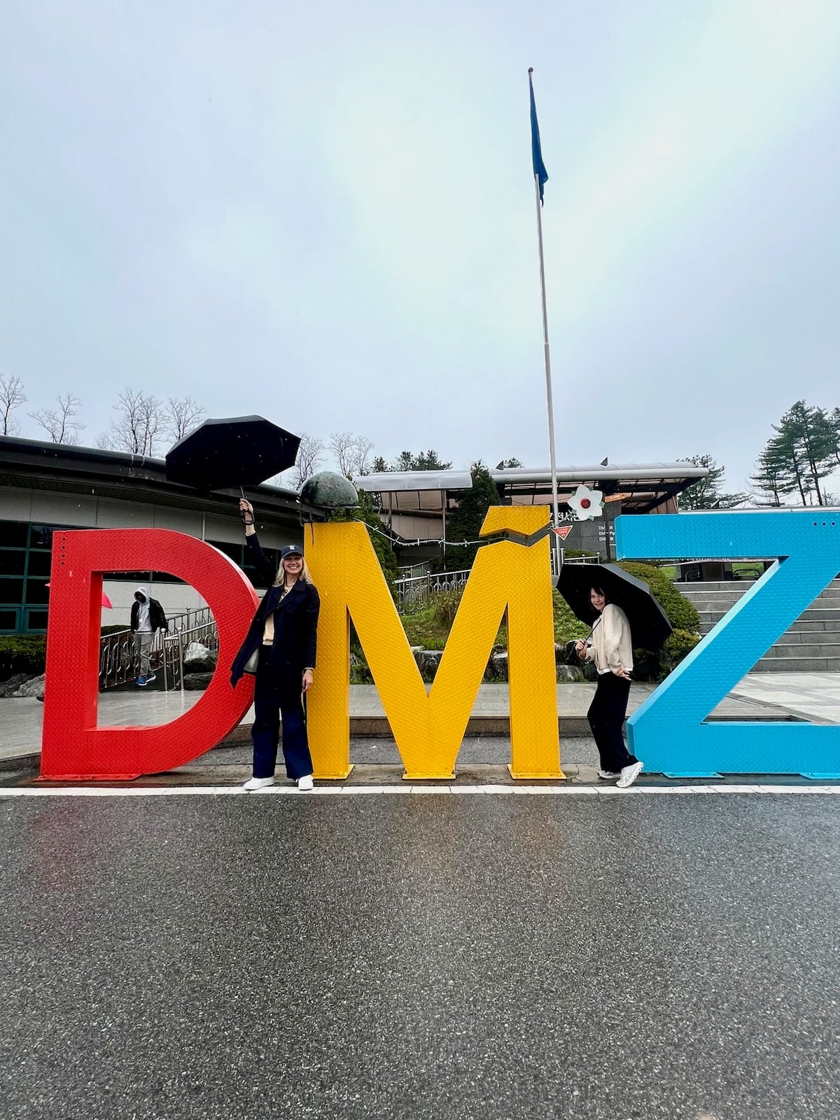 Catherine and Gemma posing with large letters "DMZ".