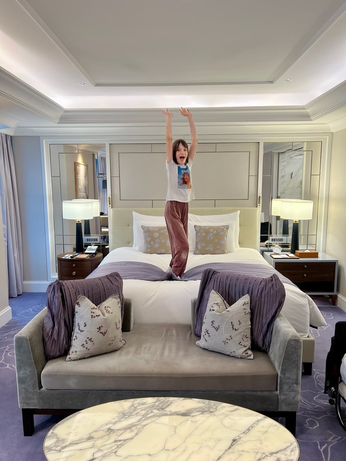 Gemma jumping on the bed in a hotel room.