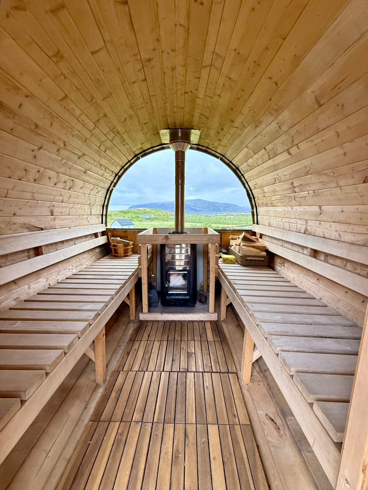 Inside a sauna overlookins green rolling hills.