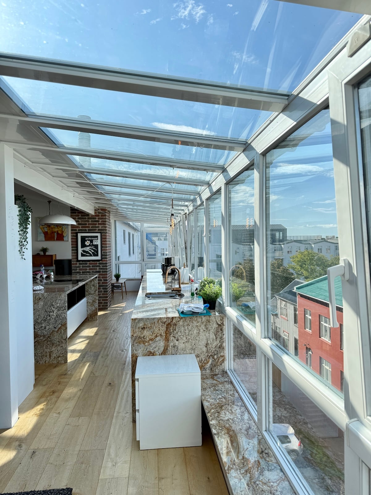Inside an apartment with glass ceiling and windows.