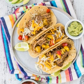 Crock pot pulled pork tacos on a plate.