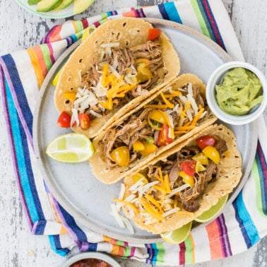 Crock pot pulled pork tacos on a plate.