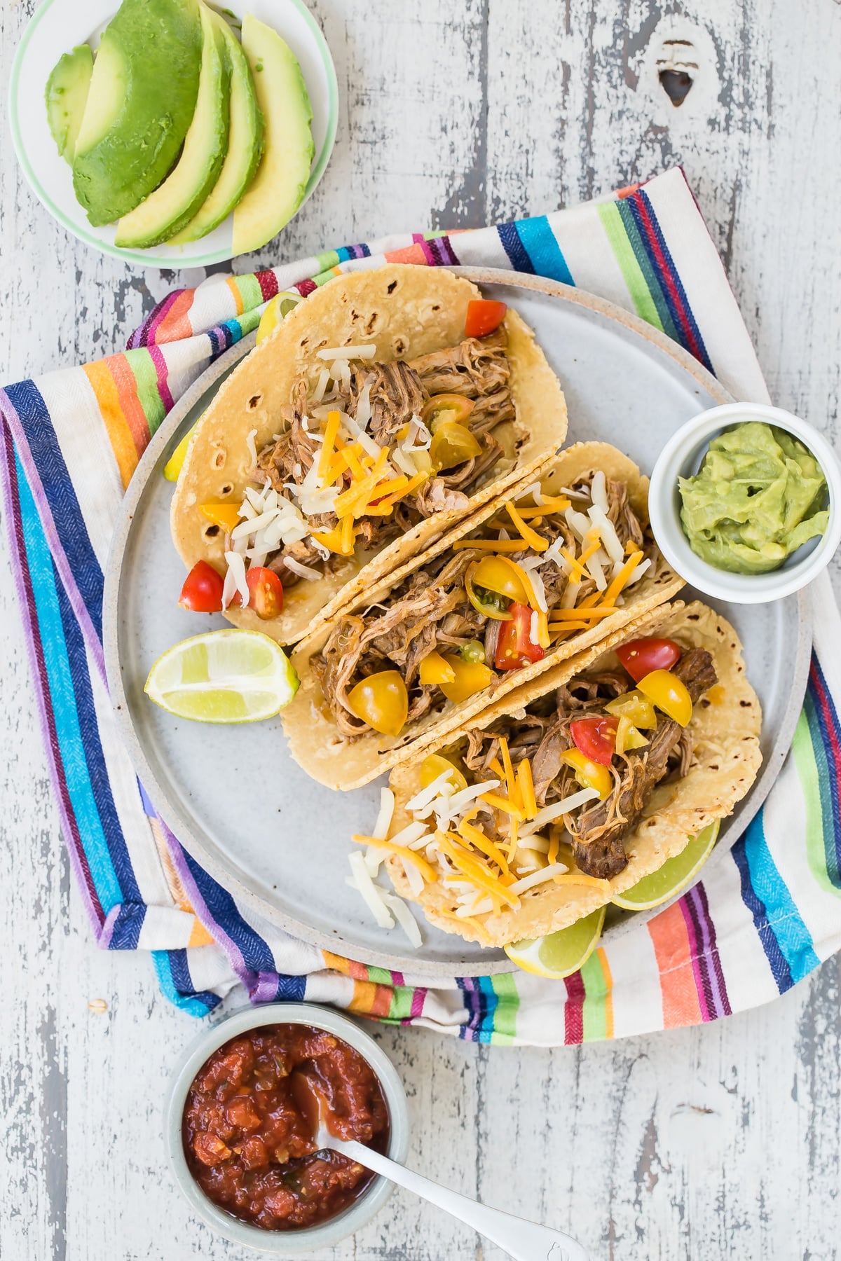 Crock pot pulled pork tacos on a plate.