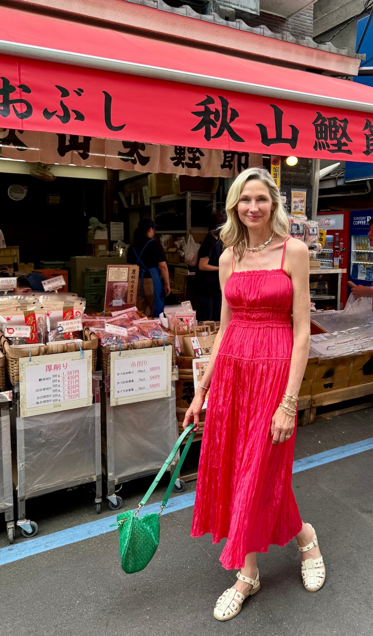 Woman posing in front of a market in Japan.