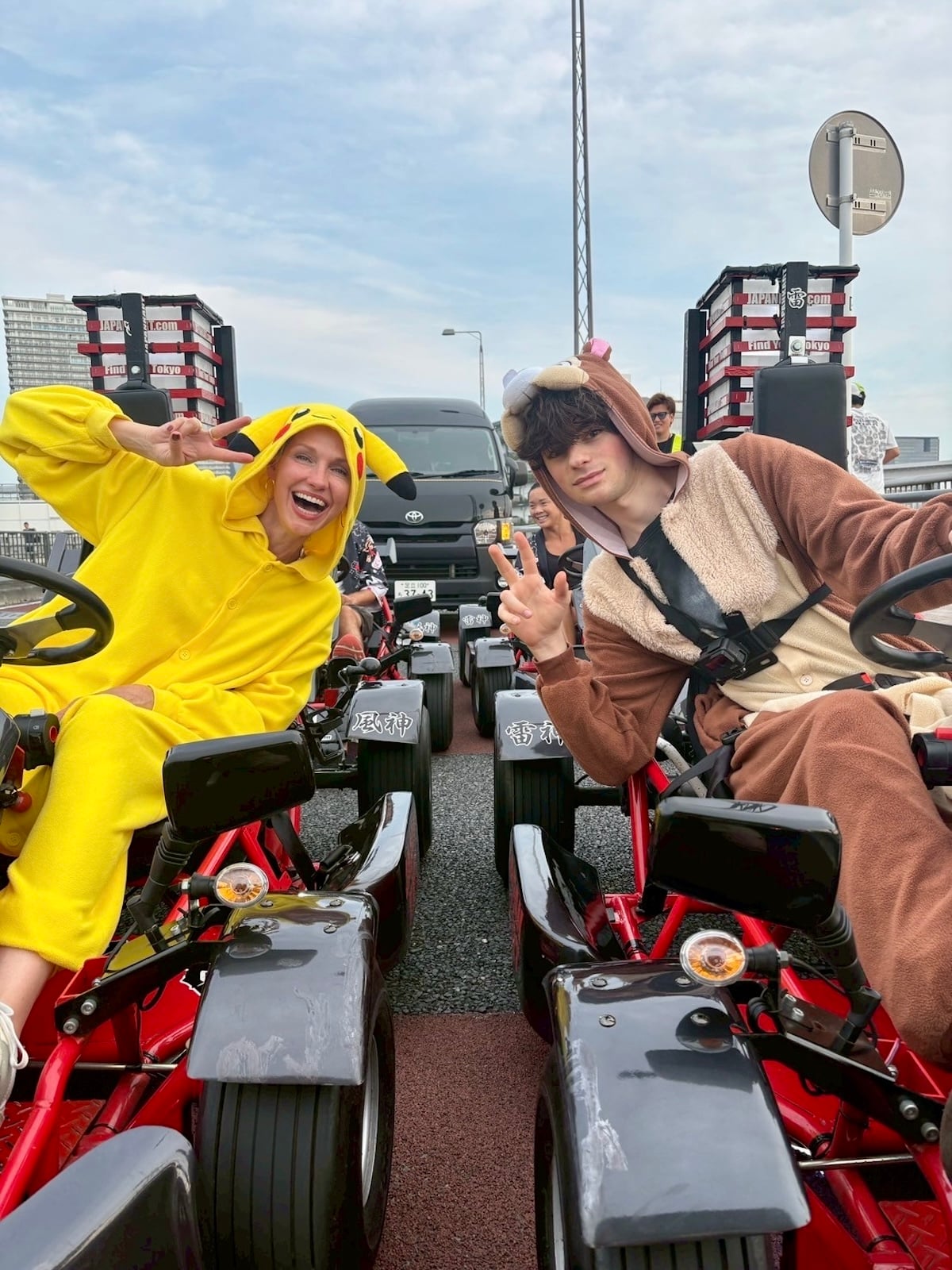 Mother and son wearing costumes sitting in go-karts.