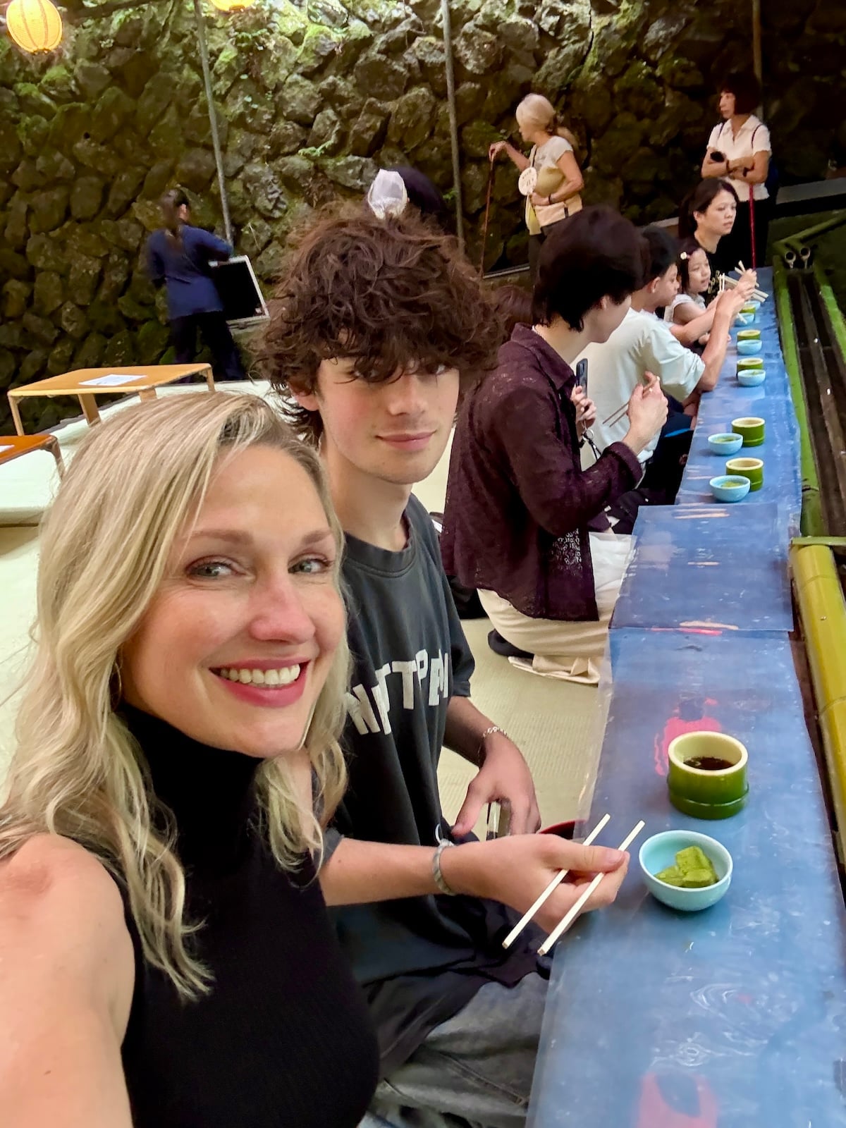 Woman and her son smiling at the camera.