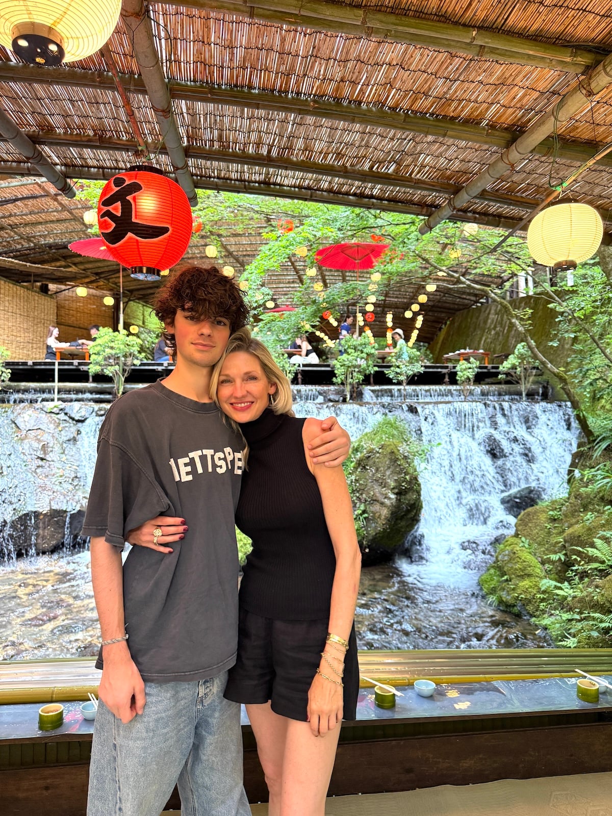 Boy and mom in front of waterfall in Japan.