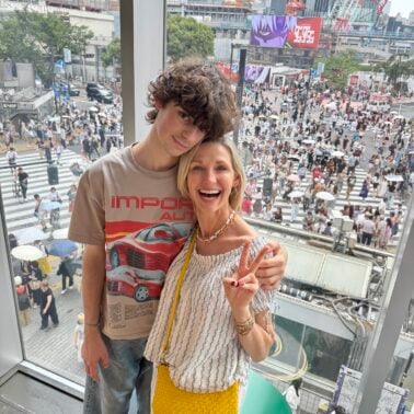 Mother and son posing in front of Shibuya scramble crossing in Tokyo.