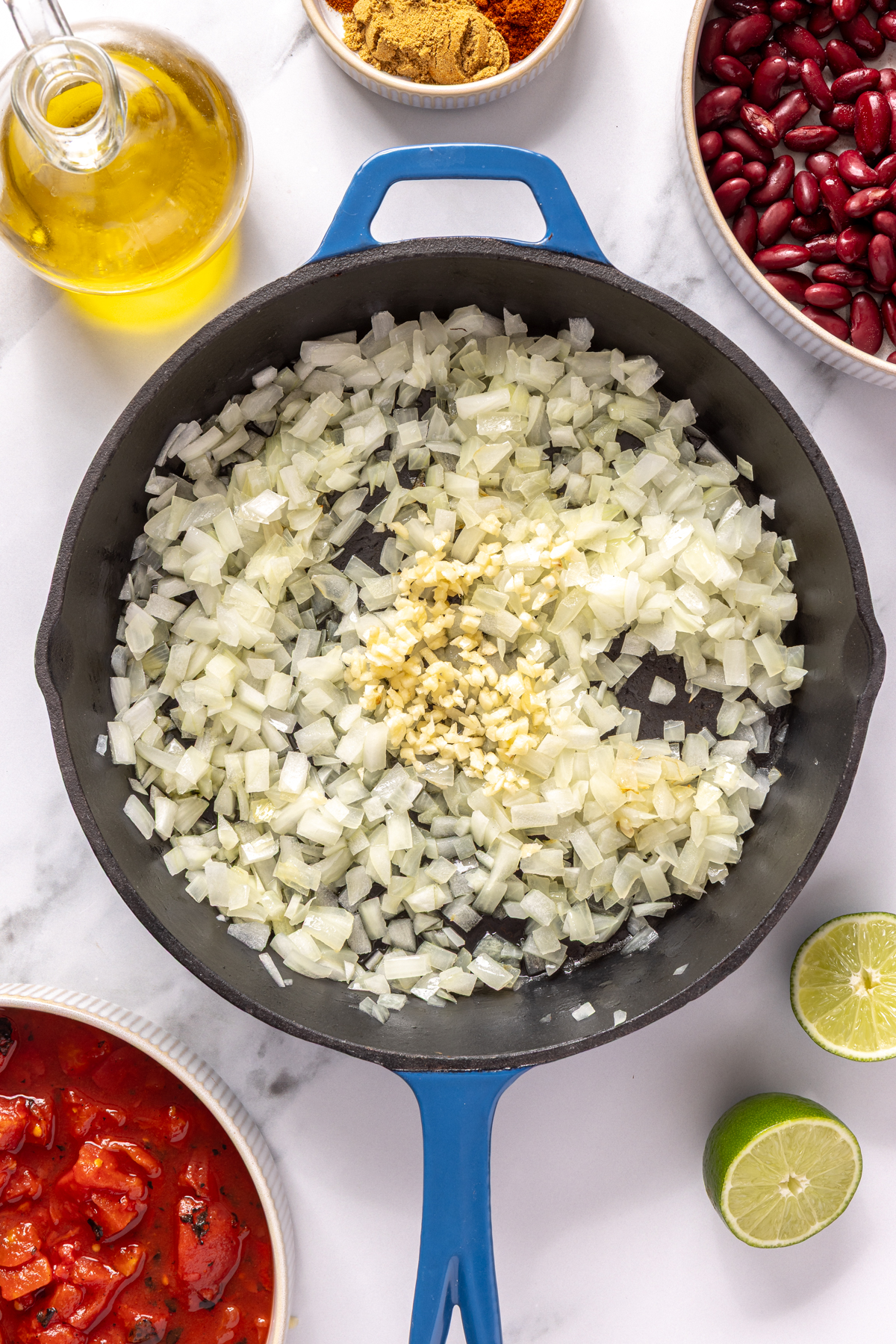 Minced garlic and diced onions in cast iron skillet.