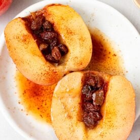 Baked apples cut in half and on a serving plate.