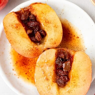 Baked apples cut in half and on a serving plate.