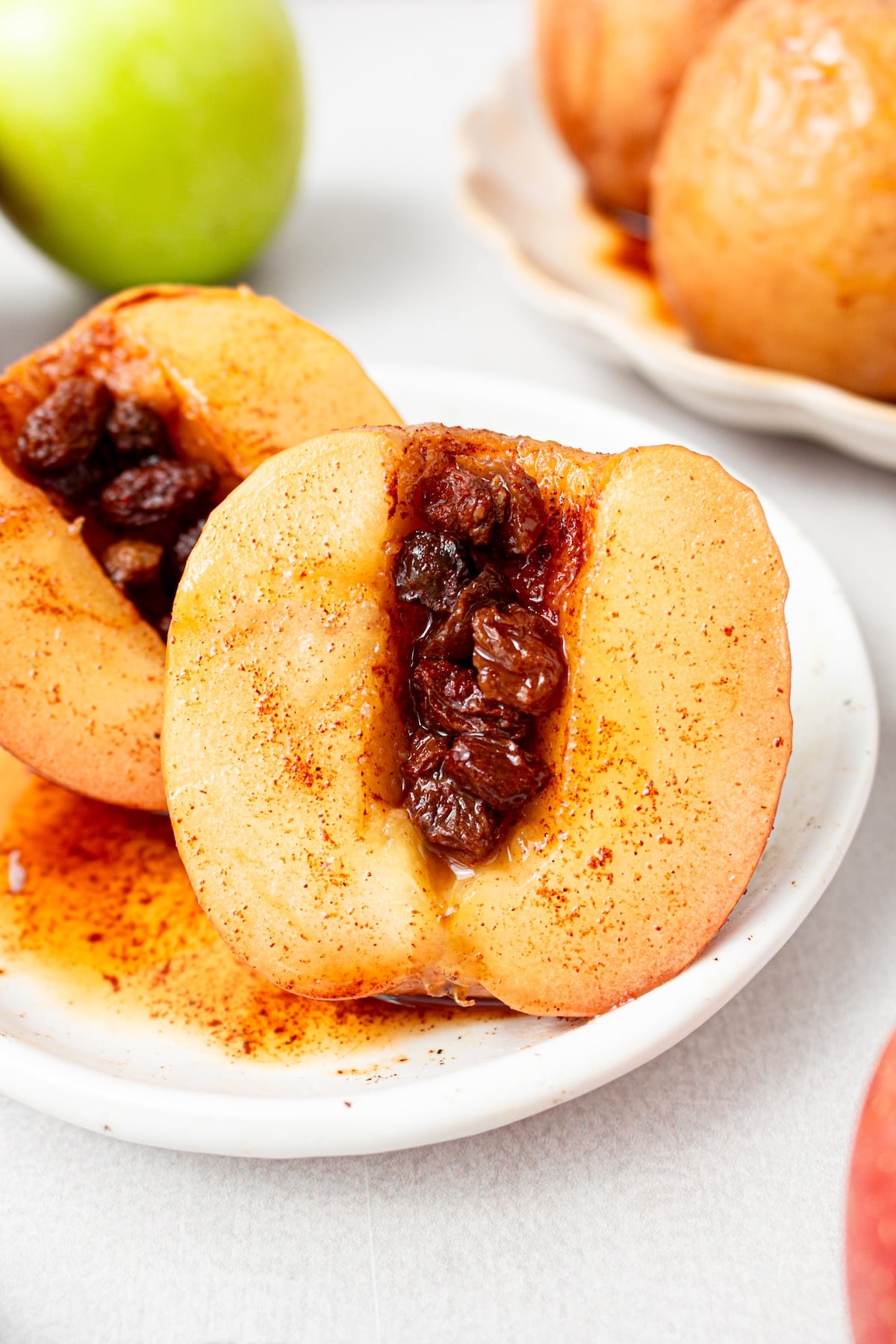 Baked apples with cinnamon and raisins on a plate.