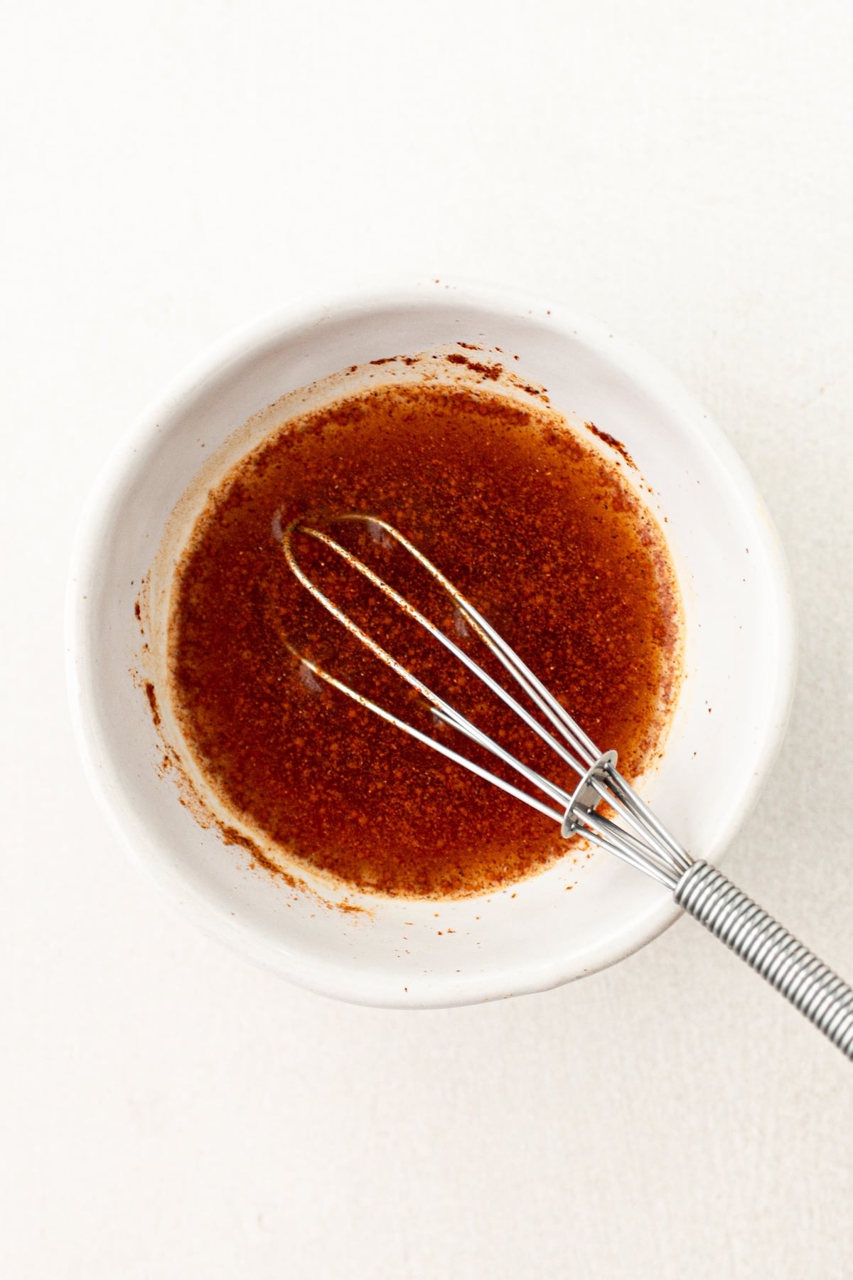 Water, cinnamon and apple juice whisked together in a small bowl.