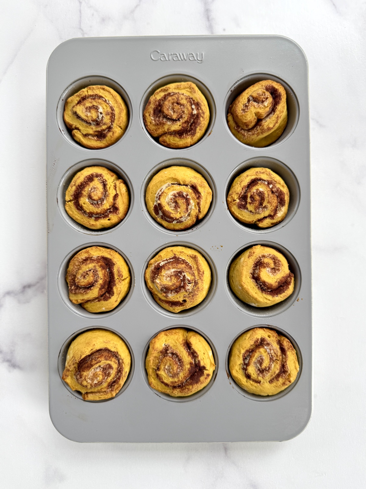 Quick pumpkin cinnamon rolls in a muffin tin.