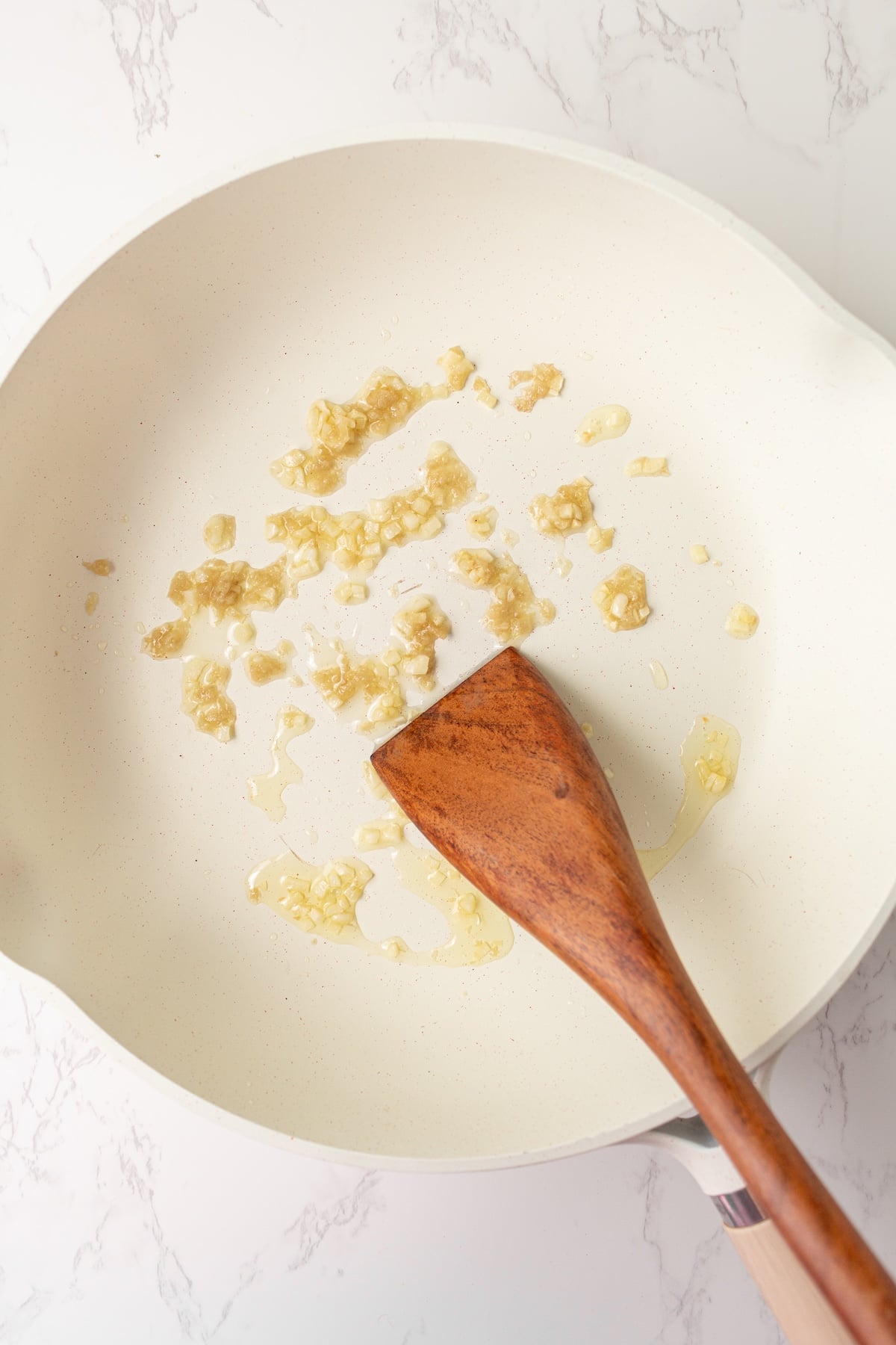 Sauteeing garlic and ginger in a pan.