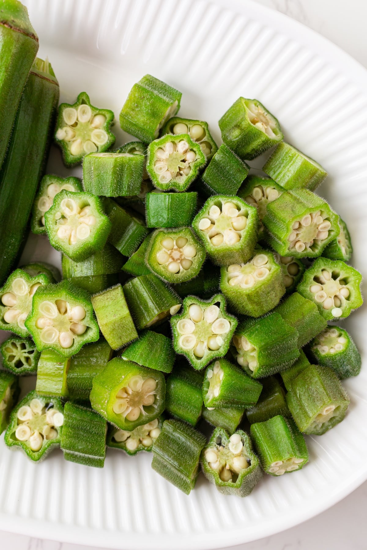 Pieces of steamed okra on a plate.
