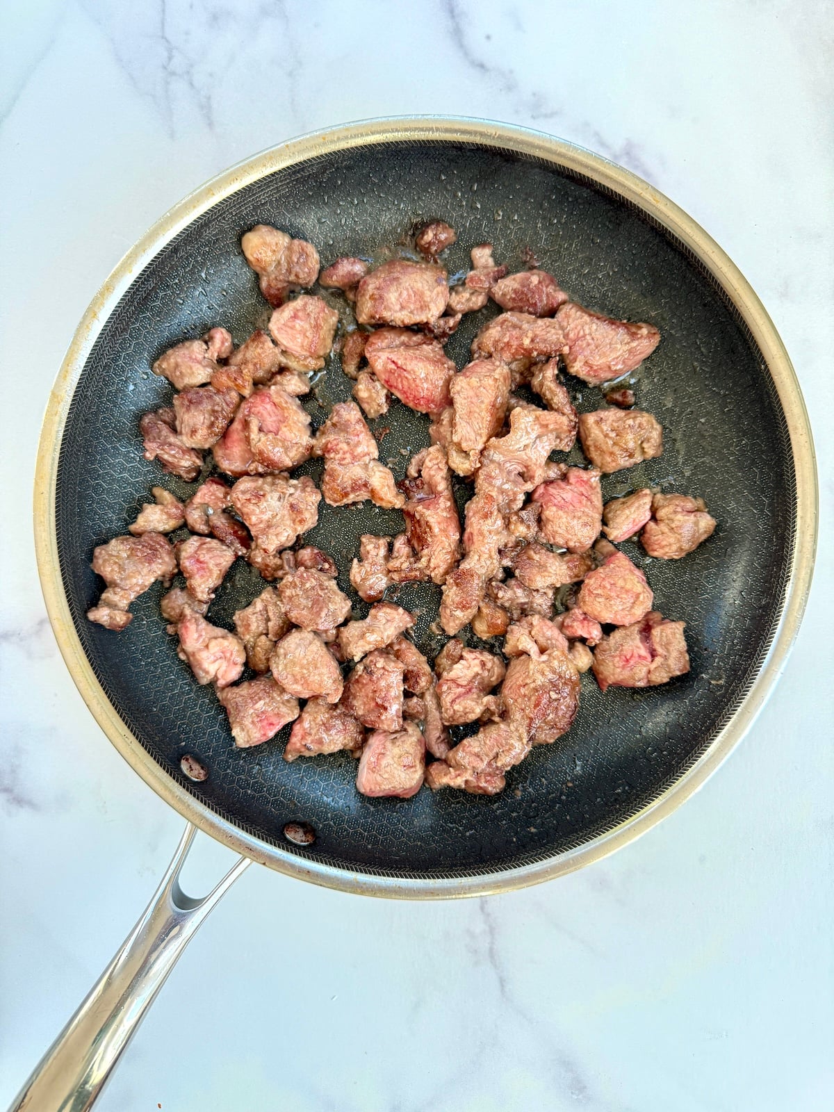Browning beef chuck in a saute pan.
