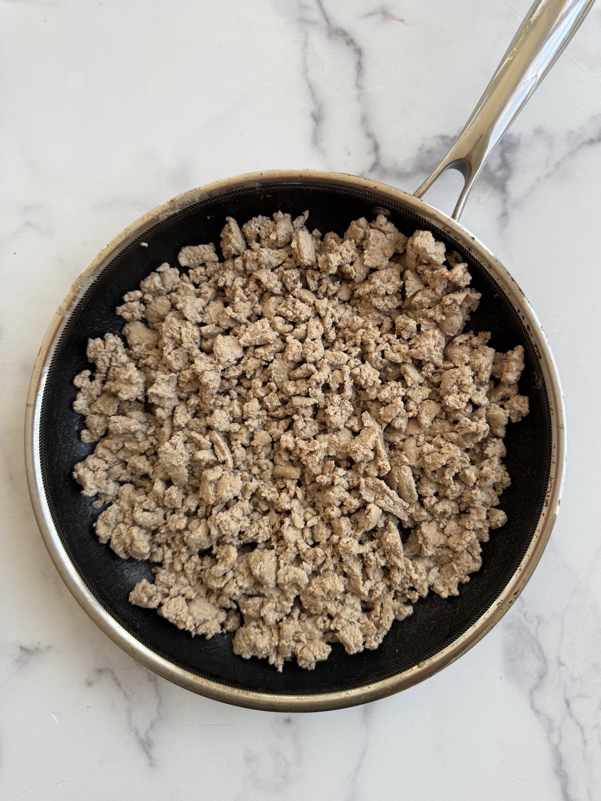Ground turkey sauteed in a pan.