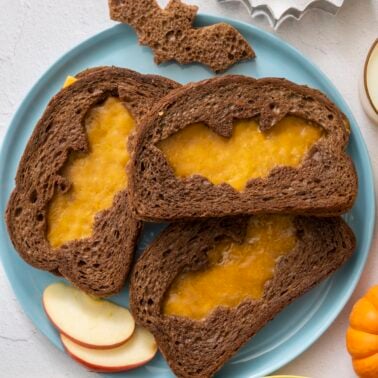 Grilled cheeses with bat- shaped cut outs for Halloween.