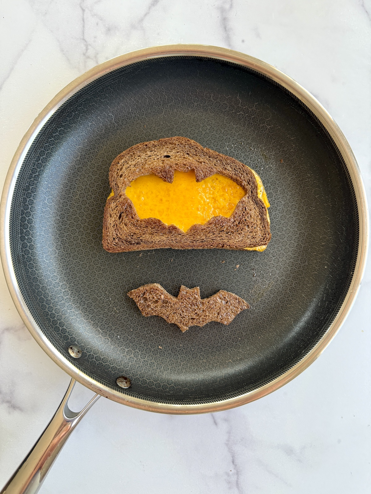 Spooky grilled cheese on a pan.