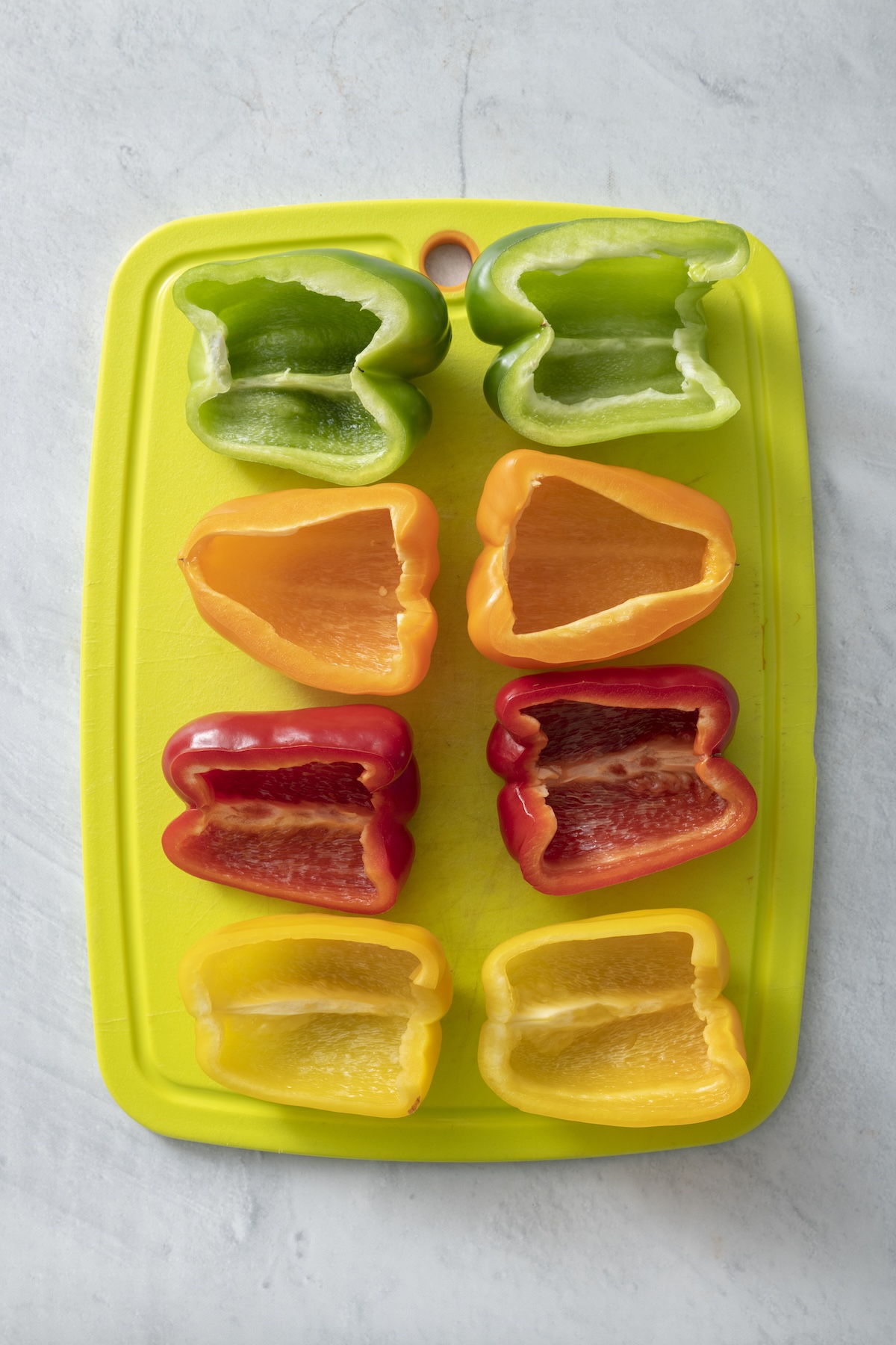 Bell peppers cut in half on a cutting board.