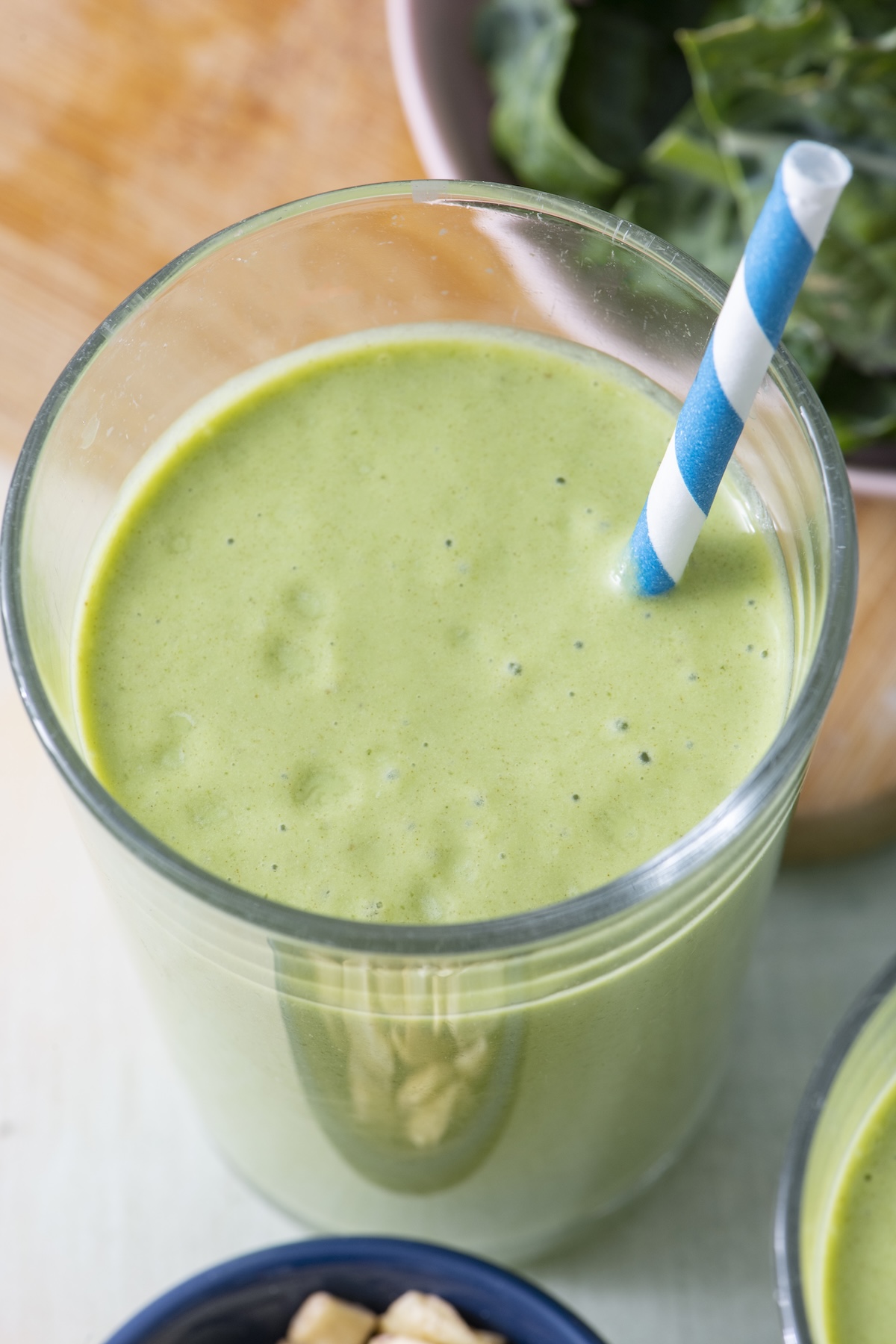 Kale smoothie with a straw.