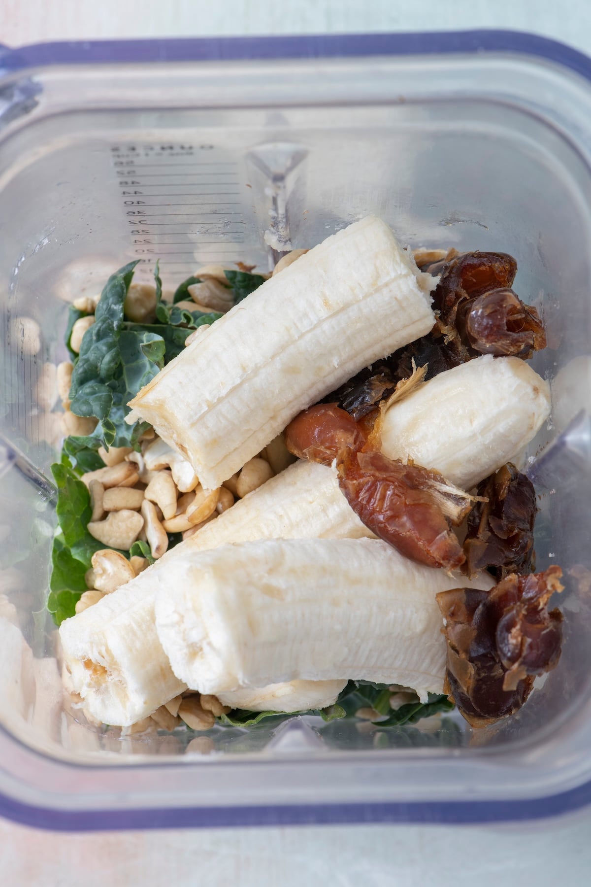 Tastes-like-ice-cream kale smoothie ingredients layered in a blender.