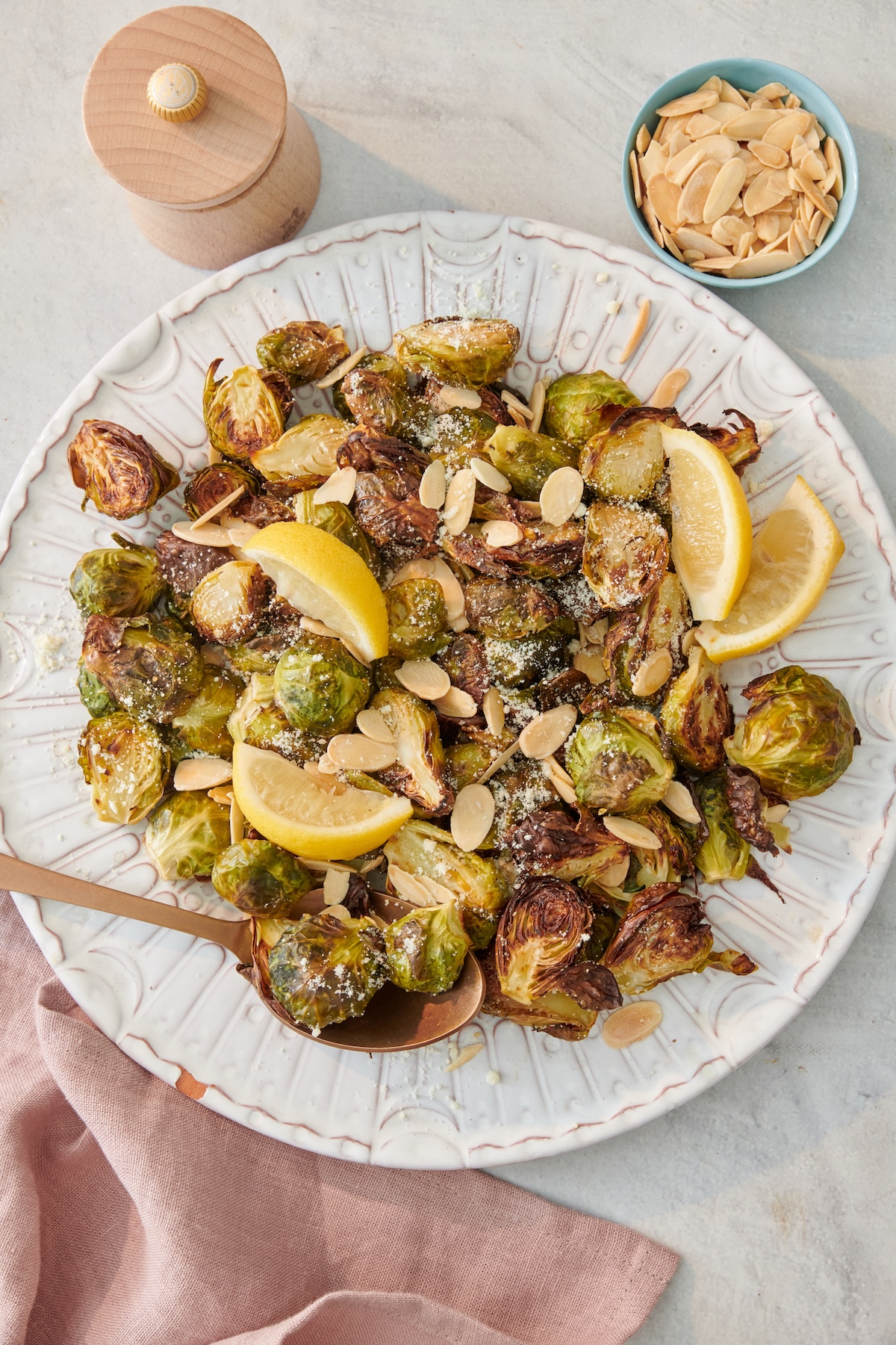 Roasted Brussels sprouts with lemon, parmesan and sliced almonds on a plate.