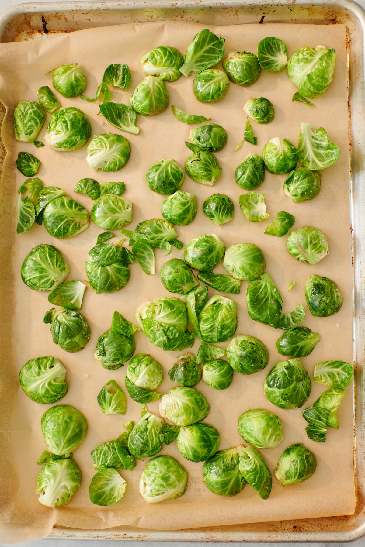 Brussels sprouts cut side down on a sheet tray.
