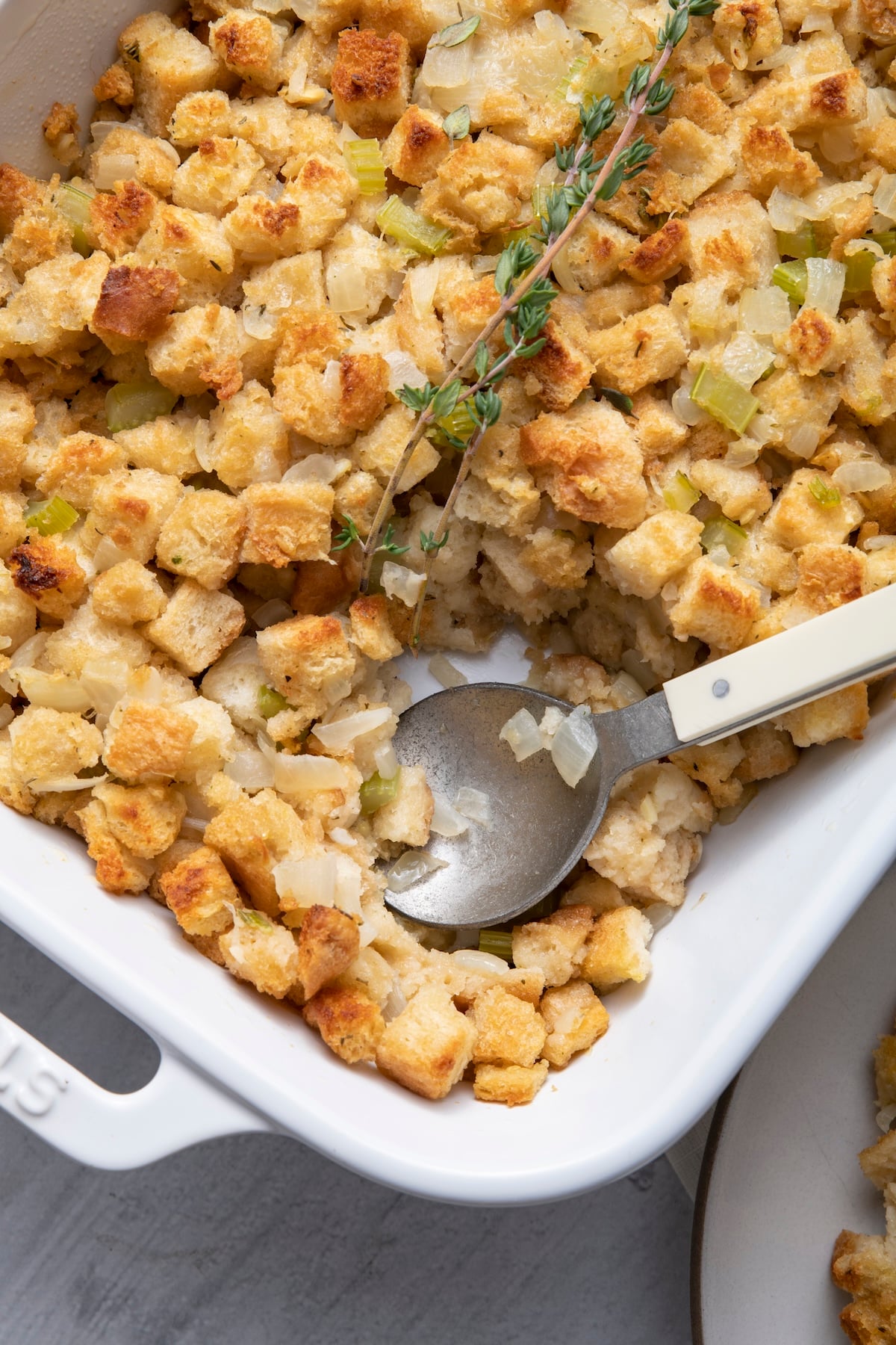 A spoon in a baking dish of super simple stuffing.