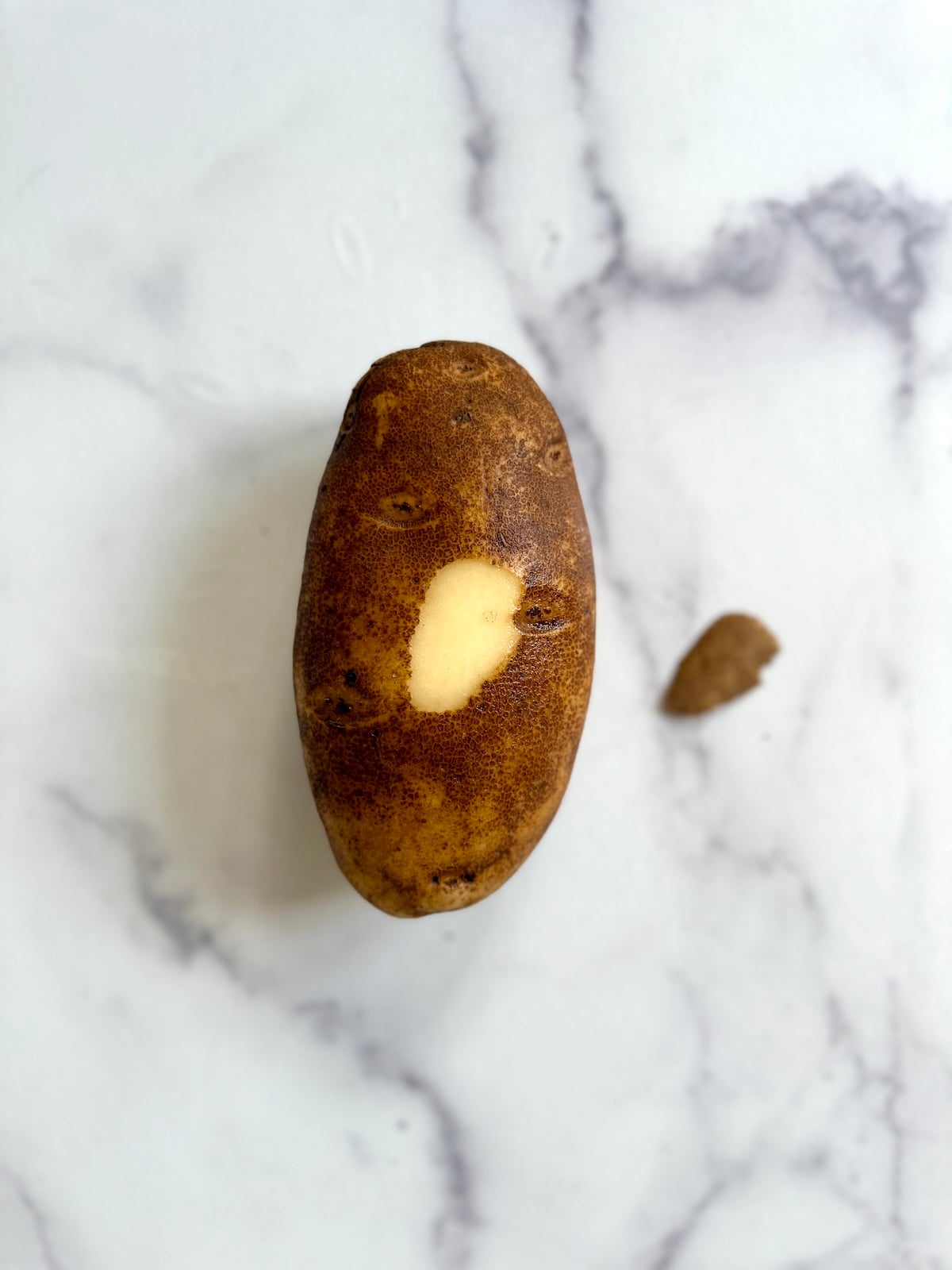 A russet potato with a small slice off the bottom.