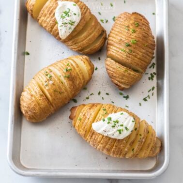 Hasselback potatoes on a sheet tray.