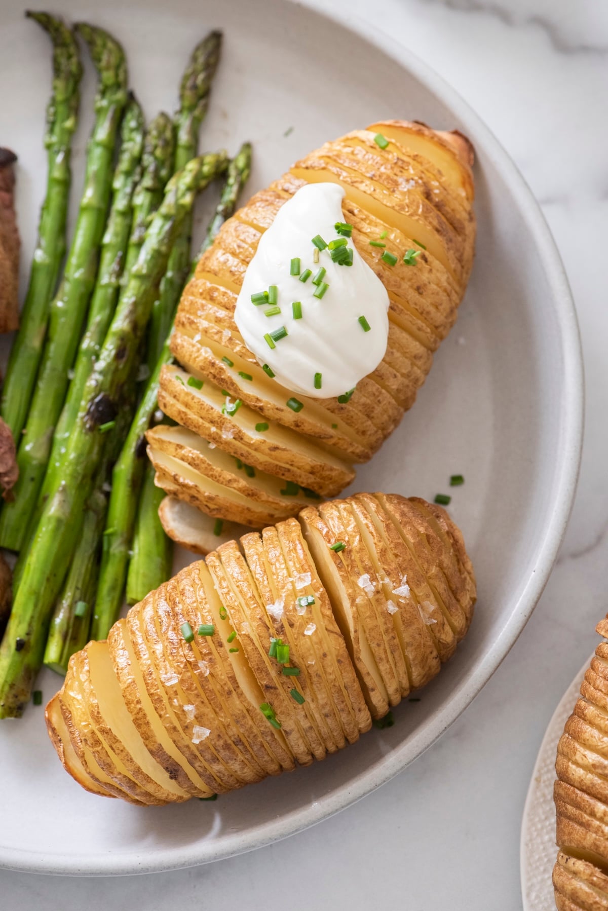 Crispy hasselback potatoes on a plate.