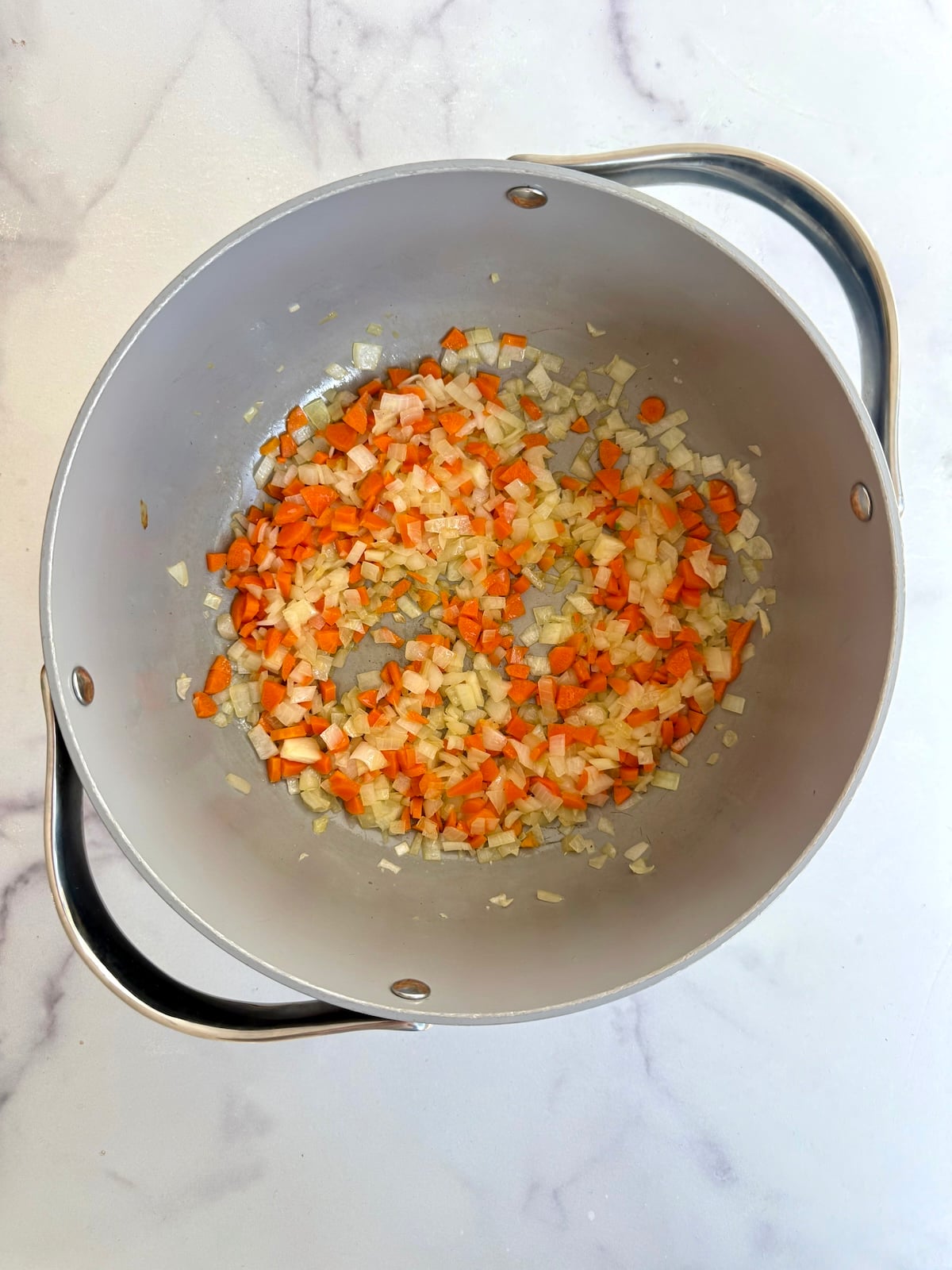 Carrots, onion and garlic in a sauce pot.