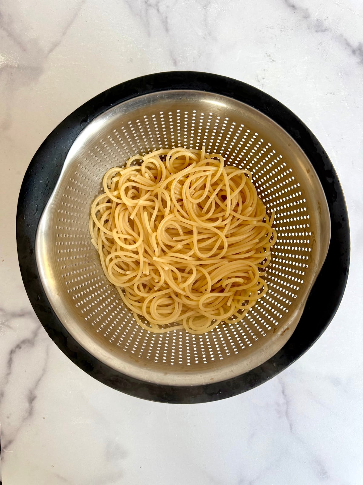 Cooked spaghetti in a colander.