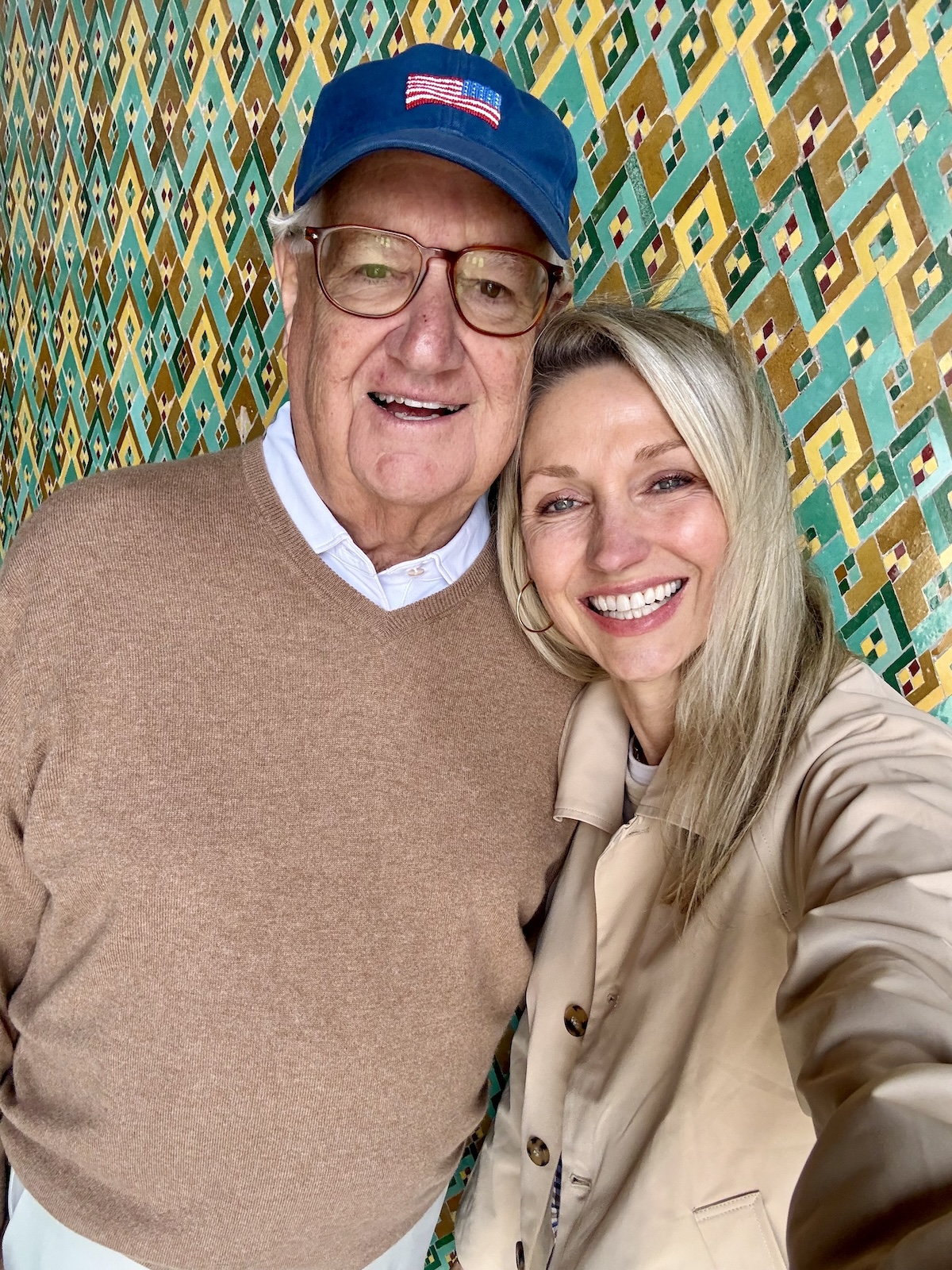Catherine and her dad taking a selfie together, smiling in front of an intricate geometric tile wall.