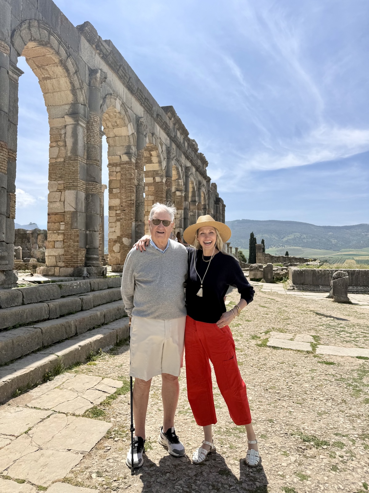 Catherine and her dad standing in front of the ancient Roman triumphal arch at Volubilis.