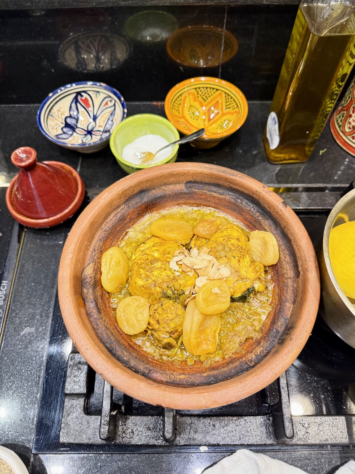 Close-up of a golden tajine cooking in a traditional clay pot.